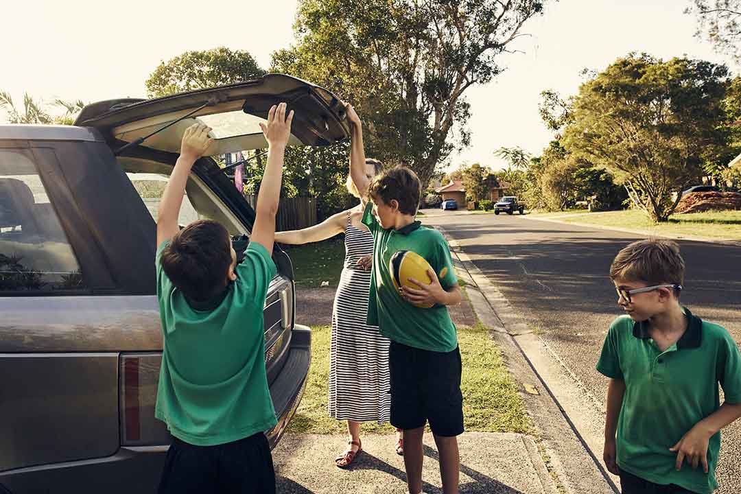 A soccer mom with her children getting ready to leave for a game